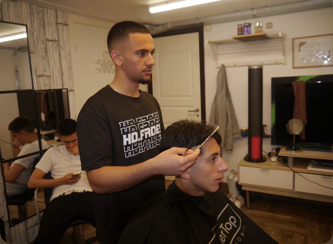 Hassan Danun klipper en kund vid sin barberarstol hos HD FADES